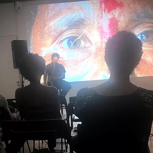 a musician plays in front of a big portrait