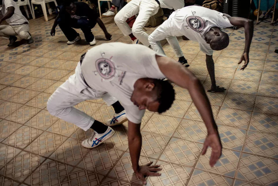 Multiple youth in white clothing performing acrobatic backbends