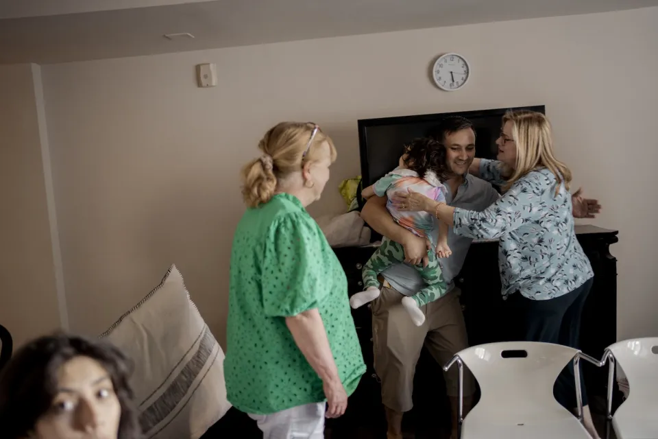 Volunteer Stephanie embraces Haroon after the family&rsquo;s asylum approval