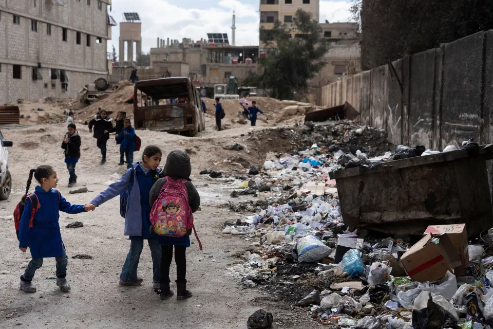 schoolchildren in a devastated street
