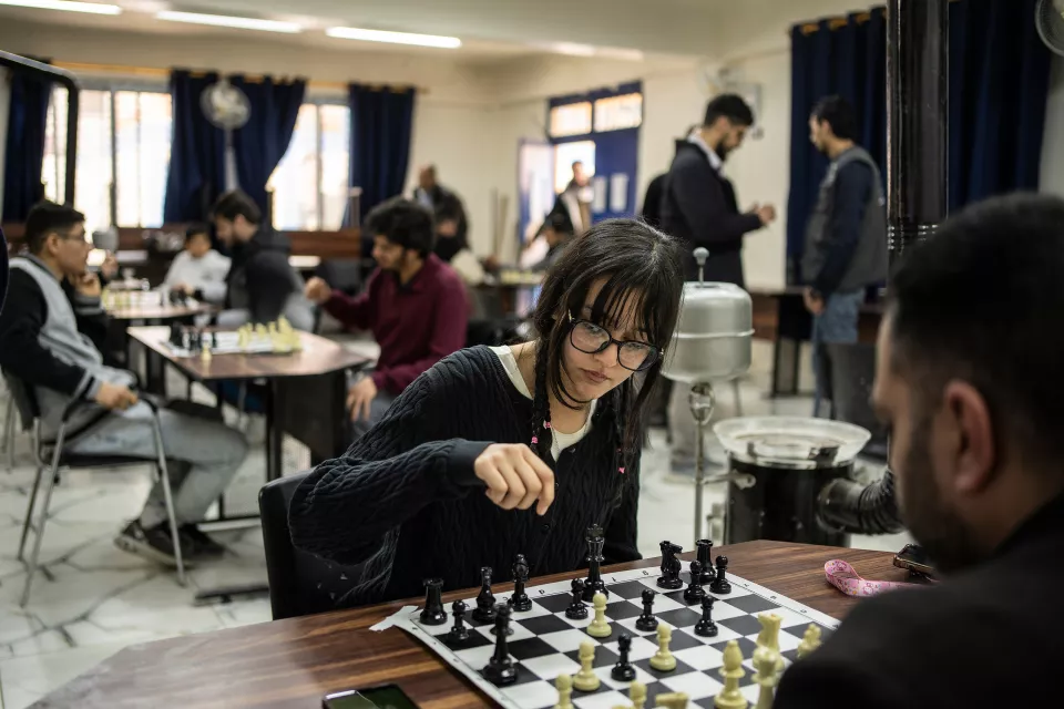 A girl playing at a chess tournament is being held in honor of his friend Hussein Taha, who died during the siege in 2015