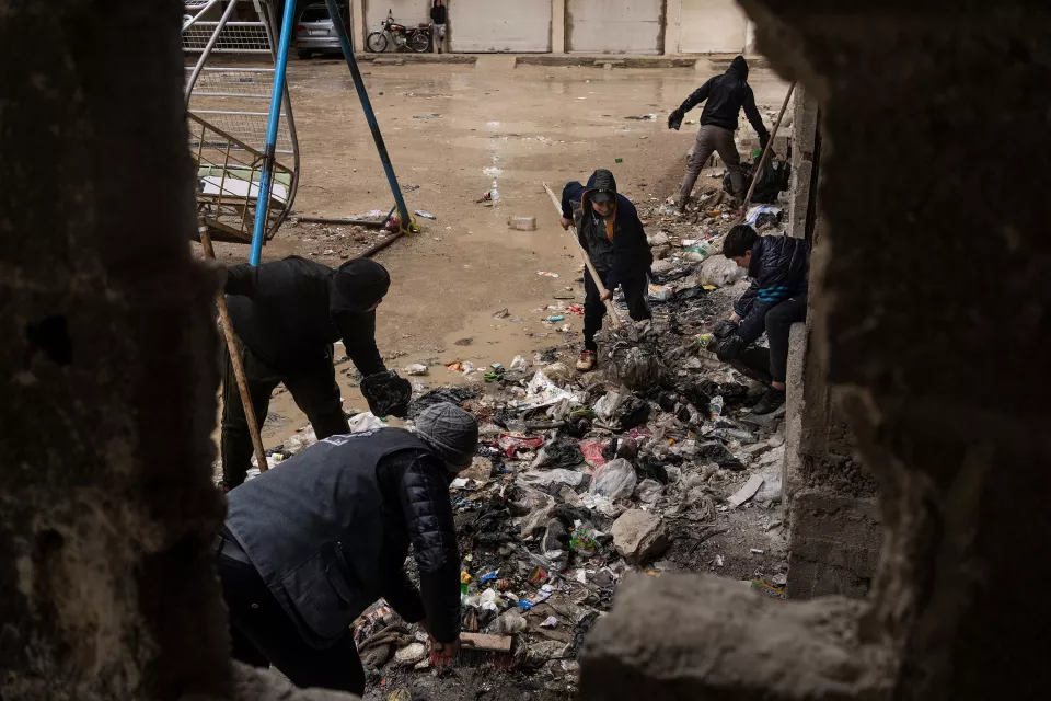 Men clean up the destroyed streets