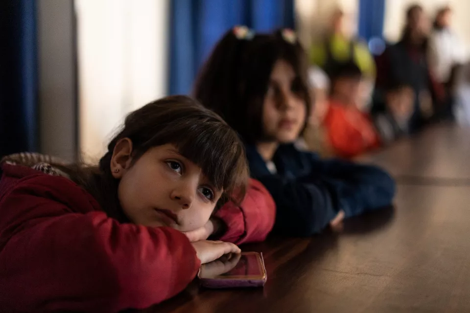close-up of a child listening with her head resting on her arms.